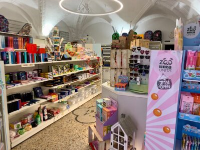 Vista interna della cartolibreria QUADRIFOGLIO con scaffali di libri, giochi e cancelleria